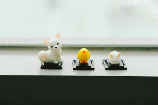 two white and yellow cat figurines
