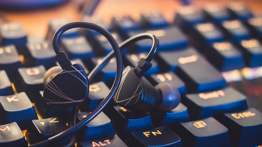 black and silver headphones on blue computer keyboard